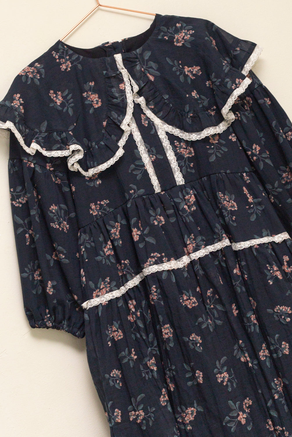 Vestido infantil romántico de voile de algodón azul noche con estampado floral y detalles de encaje Valencienne. Un diseño especial y atemporal.