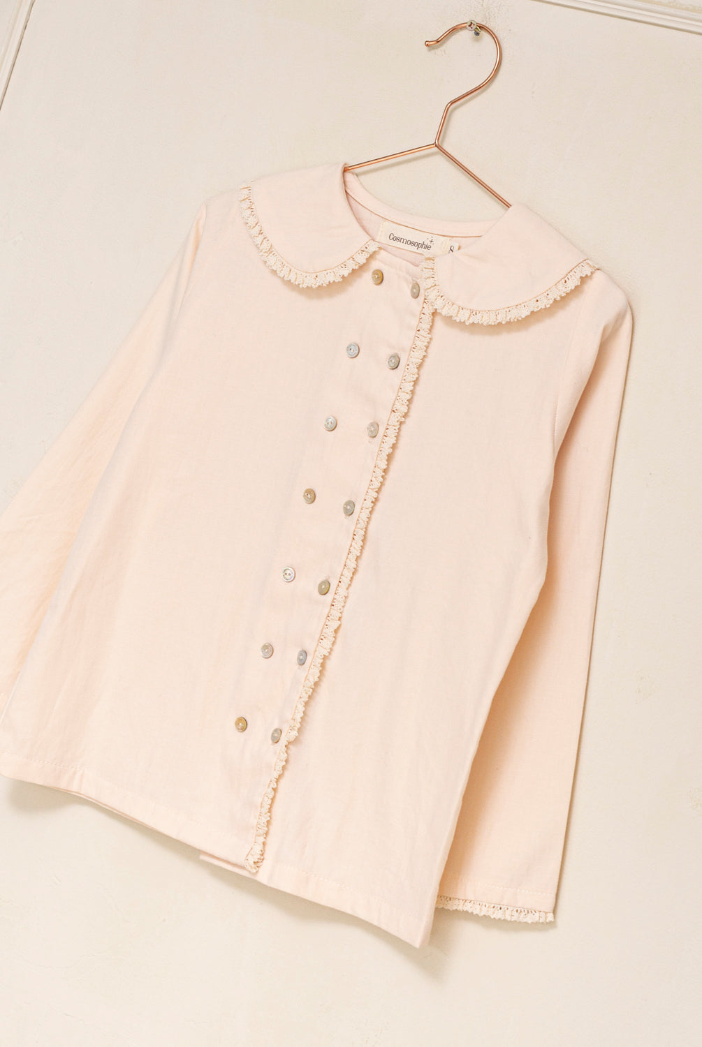 Blusa elegante para niña de algodón con cuello Peter Pan, doble botonadura y delicados detalles de encaje. Diseño atemporal de Cosmosophie para looks especiales…