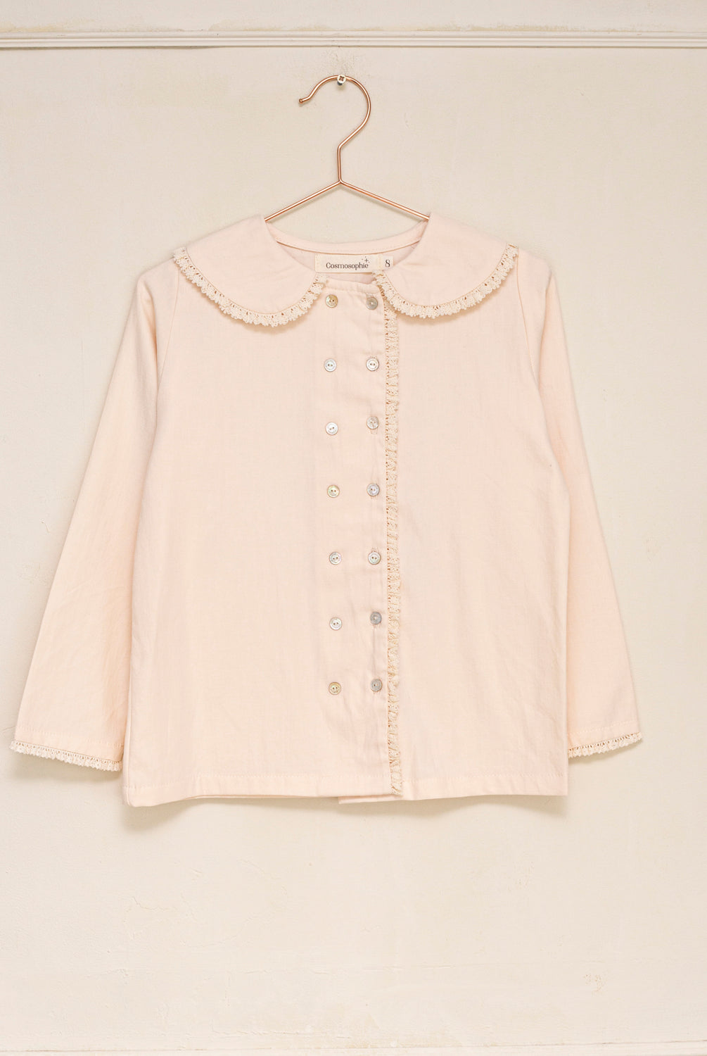 Blusa elegante para niña de algodón con cuello Peter Pan, doble botonadura y delicados detalles de encaje. Diseño atemporal de Cosmosophie para looks especiales…