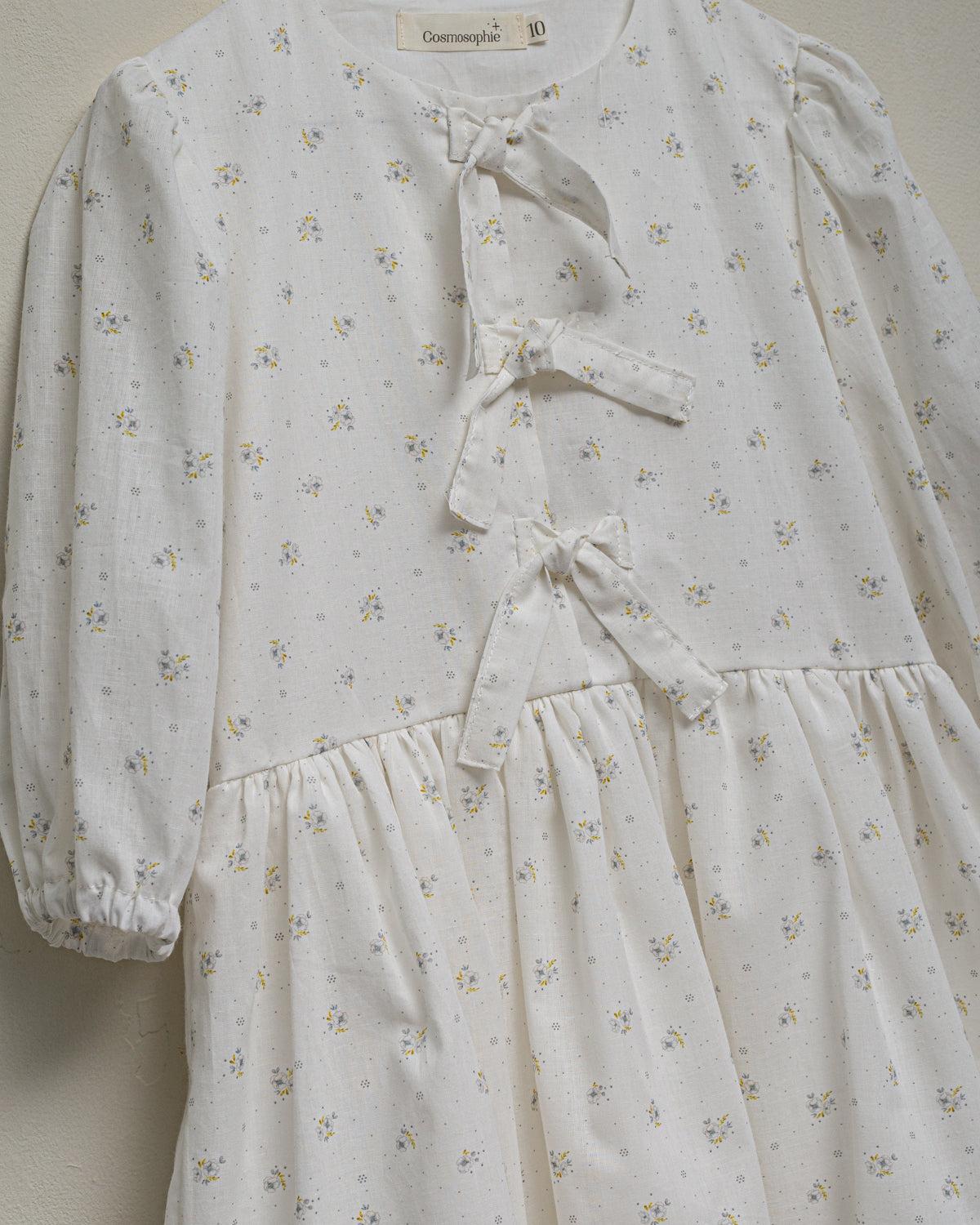 Vestido para niña de invitada con lazos en el pecho. Blanco con flores. Cosmosophie