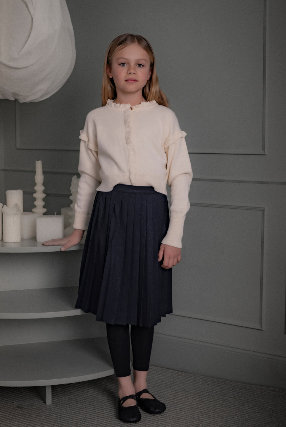 Falda Bert Glow plisada para niña, confeccionada en 100% poliéster con un sutil brillo. Diseño elegante y versátil, confeccionado en España.