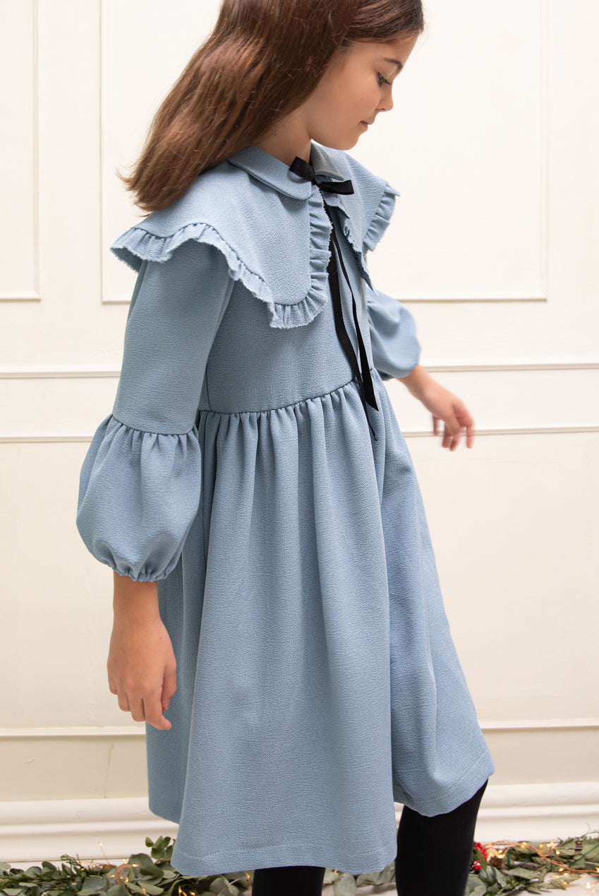 Vestido azul celeste con capita con volantes y lazo negro. cosmosophie