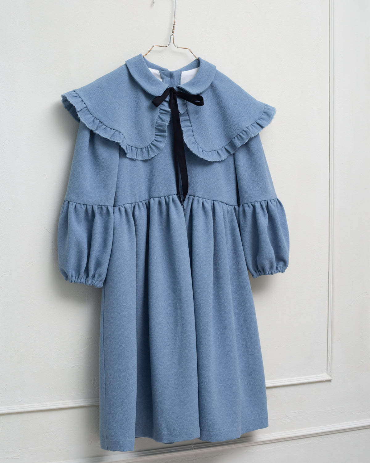 Vestido azul celeste con capita con volantes y lazo negro. cosmosophie