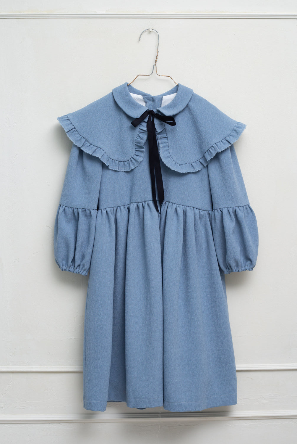 Vestido azul celeste con capita con volantes y lazo negro. cosmosophie