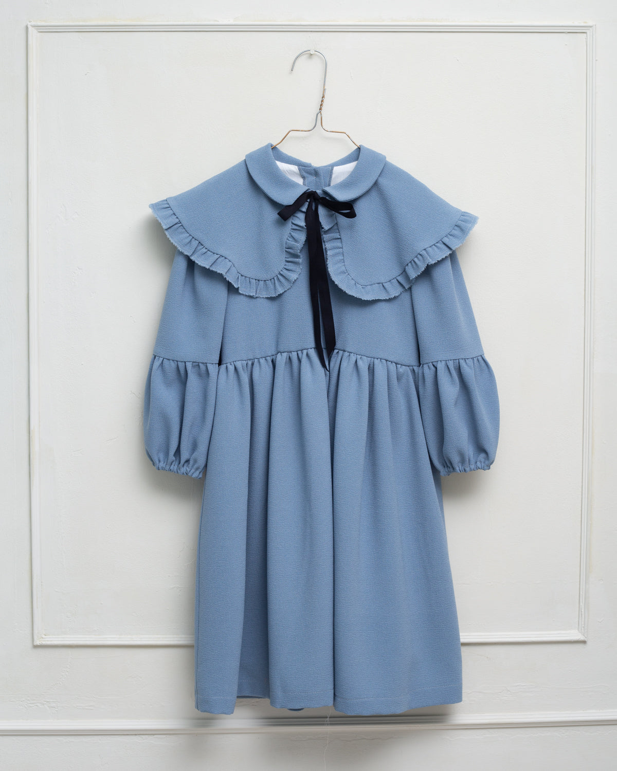 Vestido azul celeste con capita con volantes y lazo negro. cosmosophie