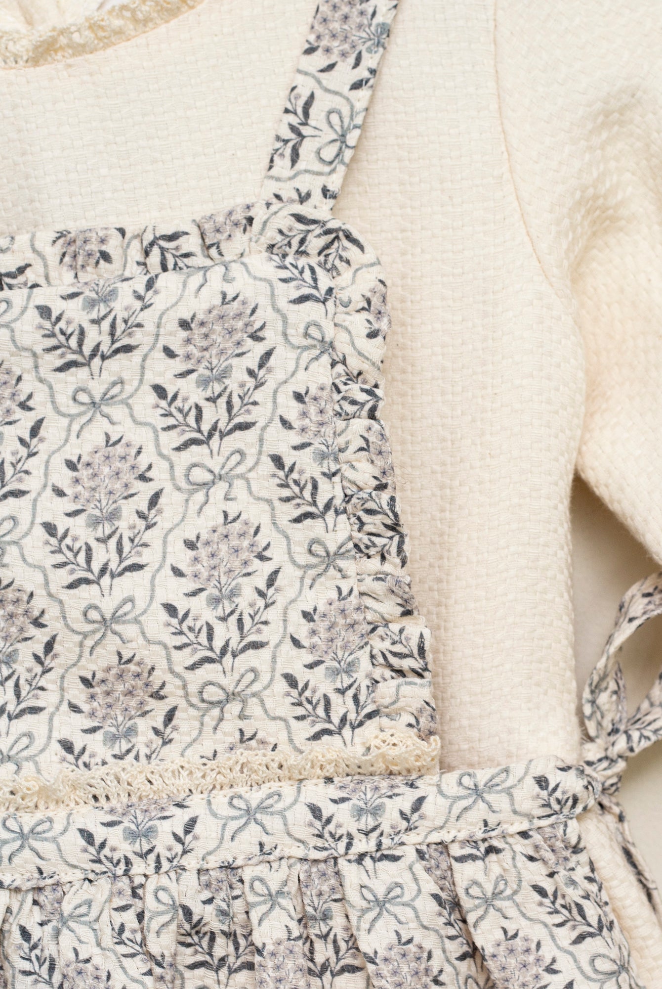 Vestido beige con delantal de flores en azul y gris de Cosmosophie