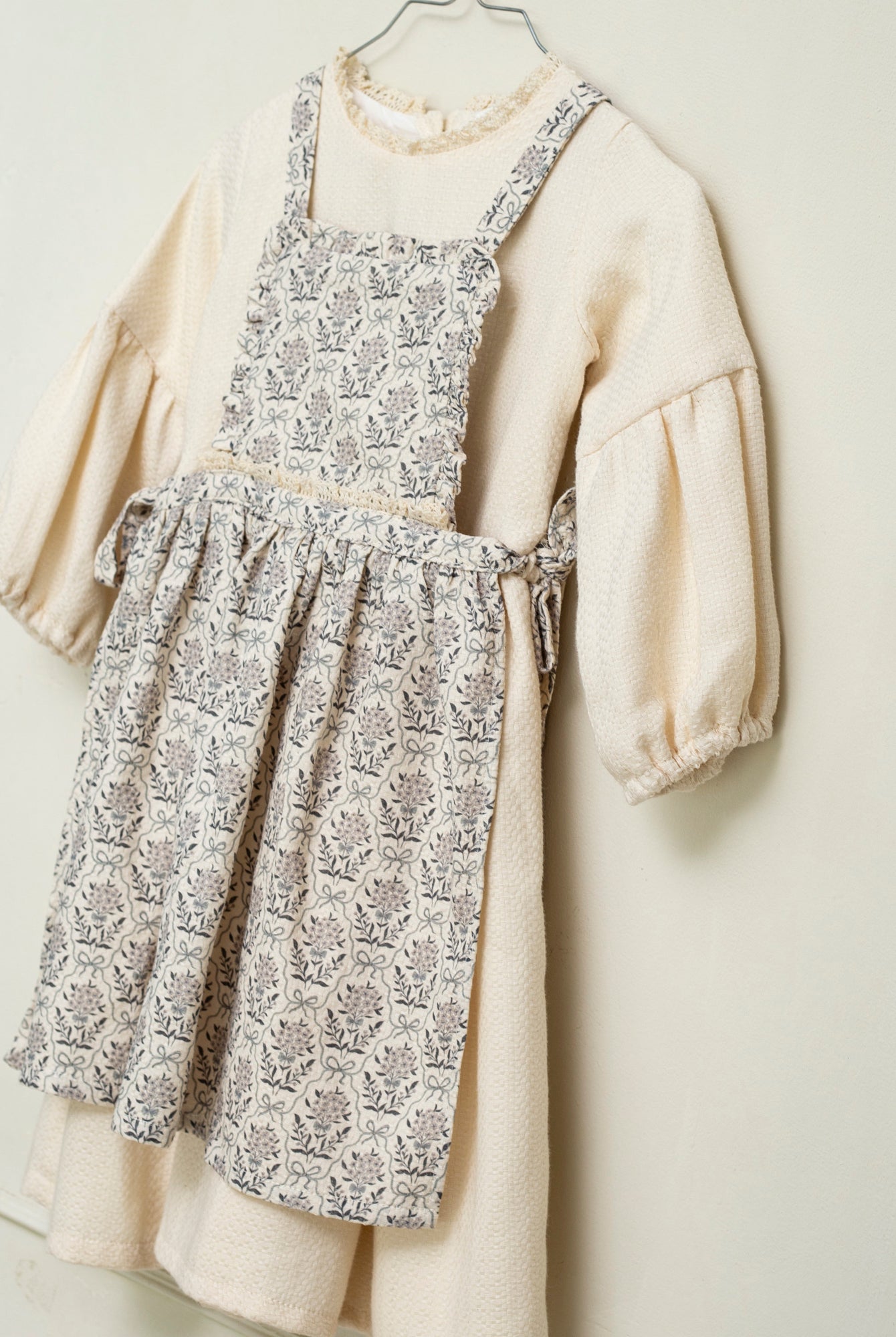 Vestido beige con delantal de flores en azul y gris de Cosmosophie