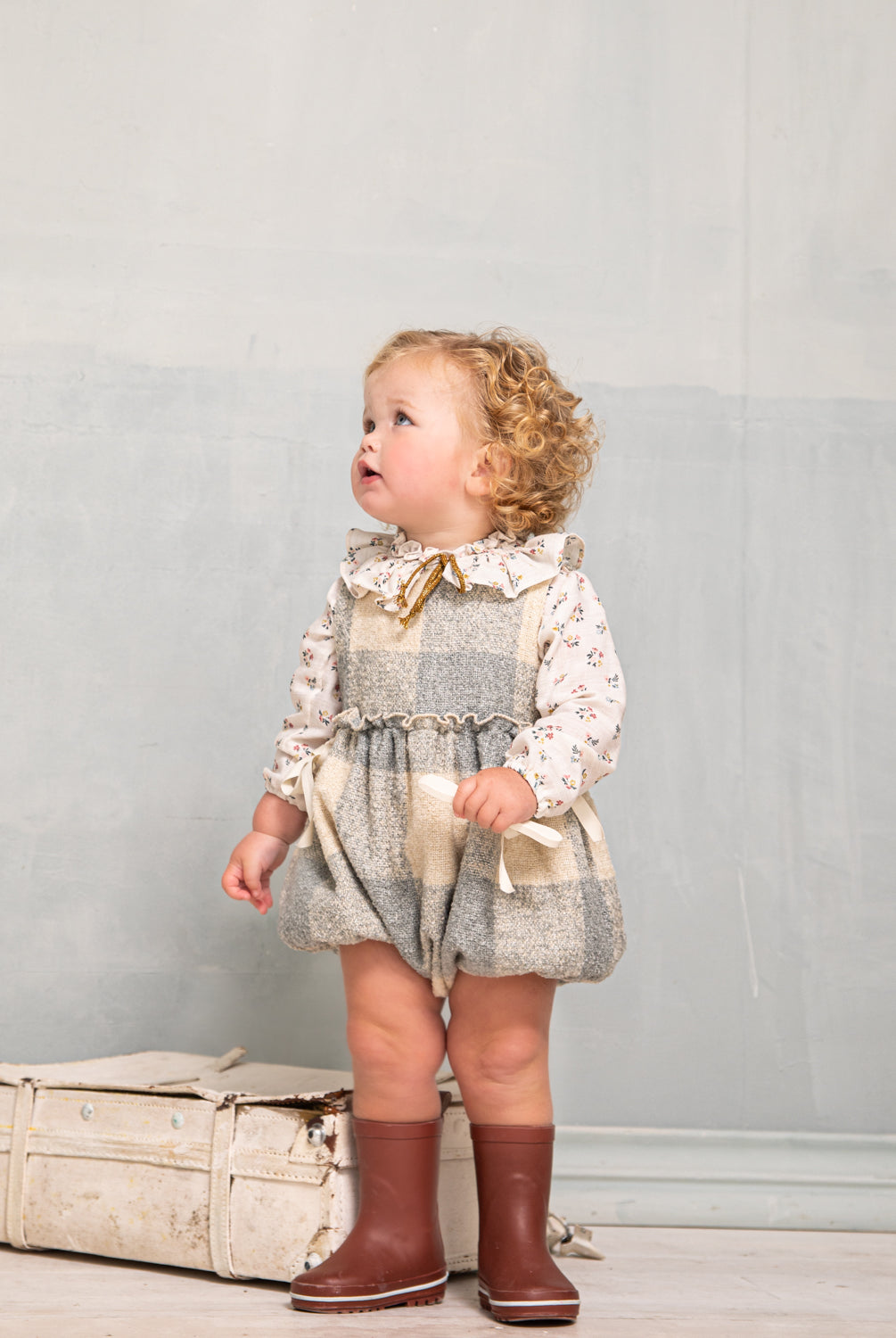 Beautiful pinafore romper in soft oversize gingham fabric in ecru and bluish grey. Perfect to wear with one of our ruffle neck blouses. You will love its bows on the sides.