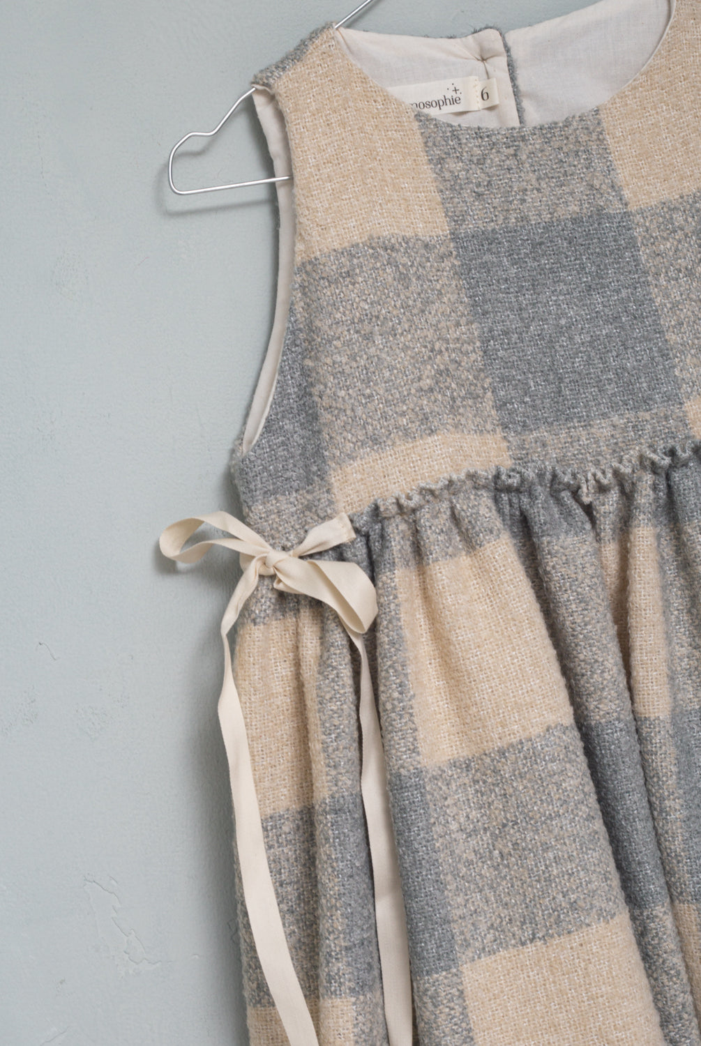 Beautiful pinafore dress in soft oversize gingham fabric in ecru and bluish grey. Perfect to wear with one of our ruffle neck blouses. You will love its bows on the sides.