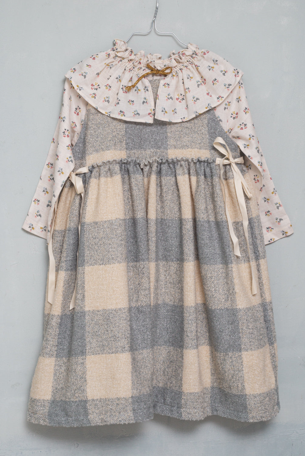 Precioso pichi en suave tejido de vichy oversize en color crudo y gris azulado. Perfecto para llevar con una de nuestras blusas de cuello de volantes. Te encantarán sus lazadas en los lados.