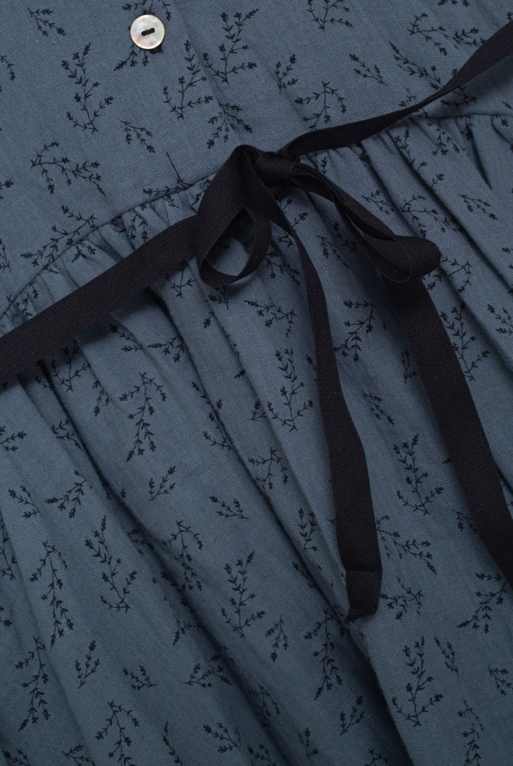 Front button dress with baby collar. You will love its blue double gauze fabric with a print of small black flowers. As details, it has a black ribbon that is tied at the waist.