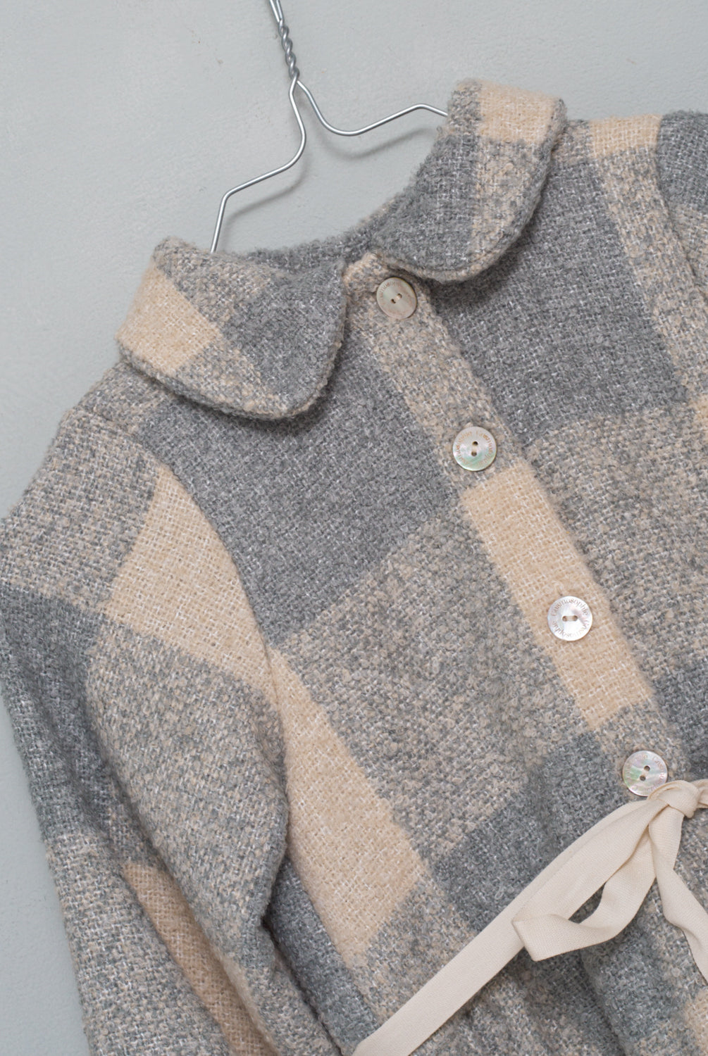 Vestido abierto por delante con botones y cuello bebe. Te encantrá su tejido de vichy oversize. Como detalle, lleva una cinta en crudo que se anuda en la cintura.