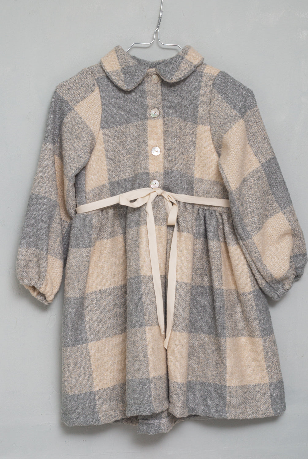 Front button dress with baby collar. You will love its oversize vichy fabric. As a detail, it has an ecru ribbon that is tied at the waist.