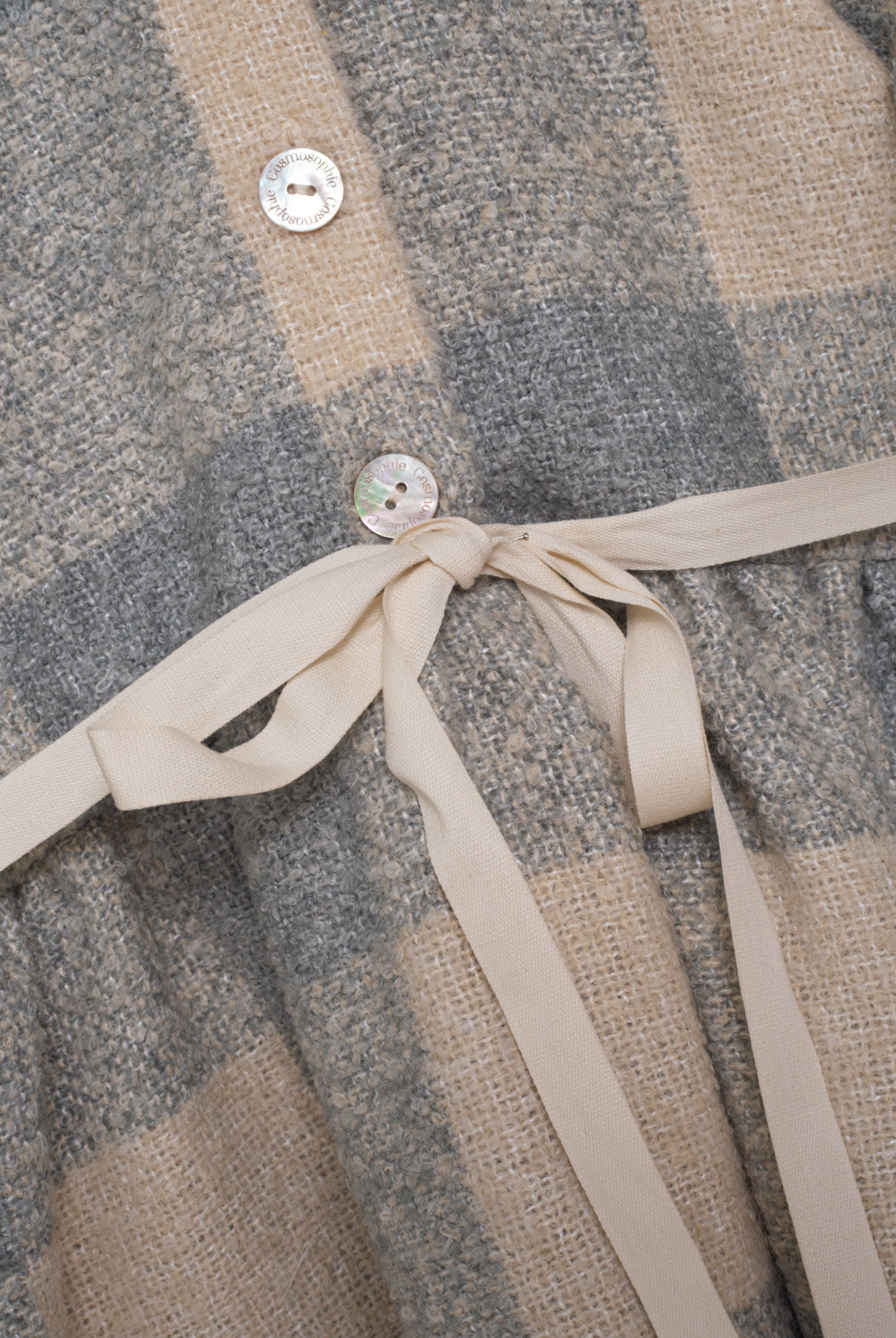 Vestido abierto por delante con botones y cuello bebe. Te encantrá su tejido de vichy oversize. Como detalle, lleva una cinta en crudo que se anuda en la cintura.