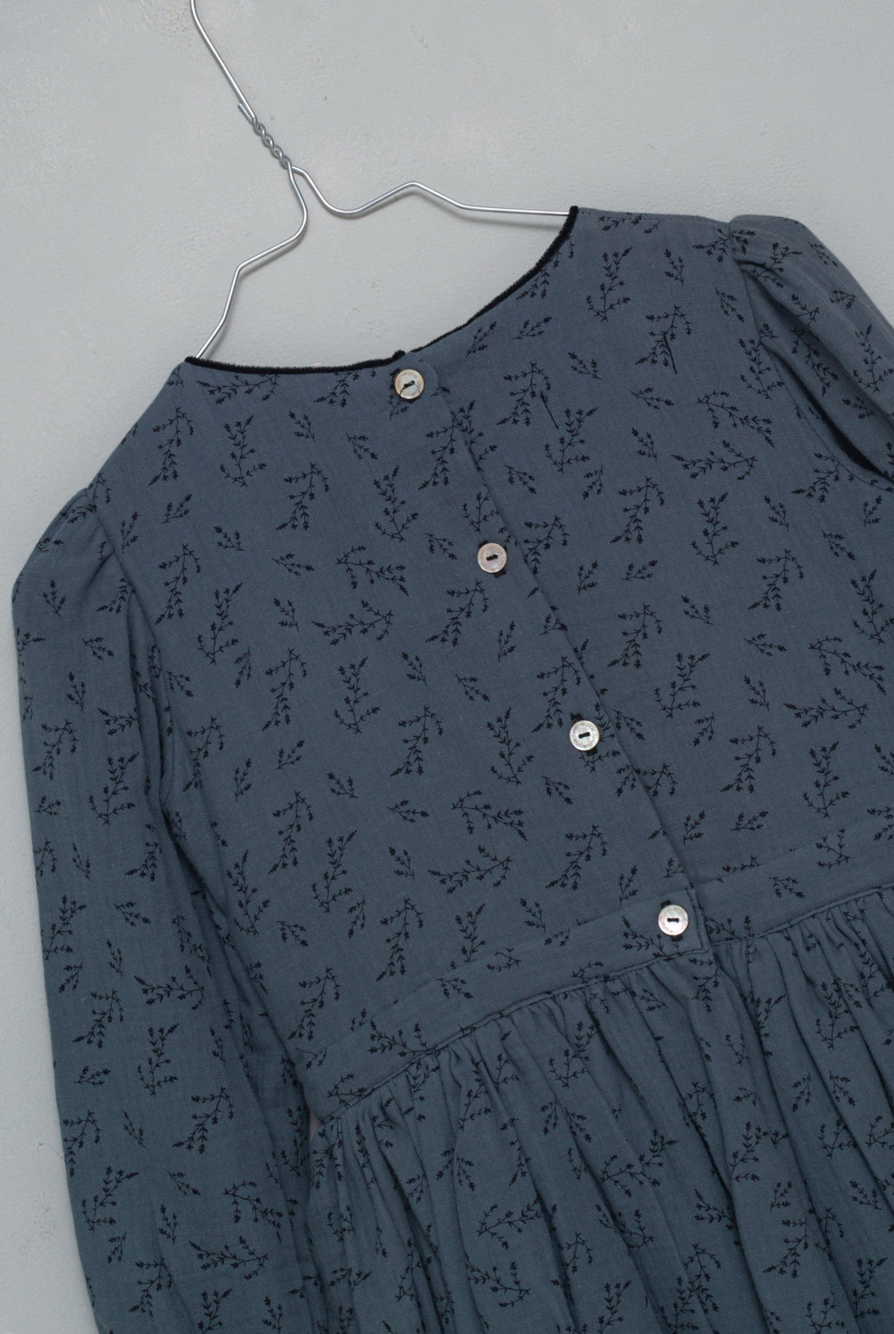 Te encantará nuestro vestido Pandora de corte vintage. Detalle en el cuello a contraste en color negro. Realizado en una preciosa tela de doble gasa algodón el estampado es de florecitas en en negro sobre fondo azul oscuro.