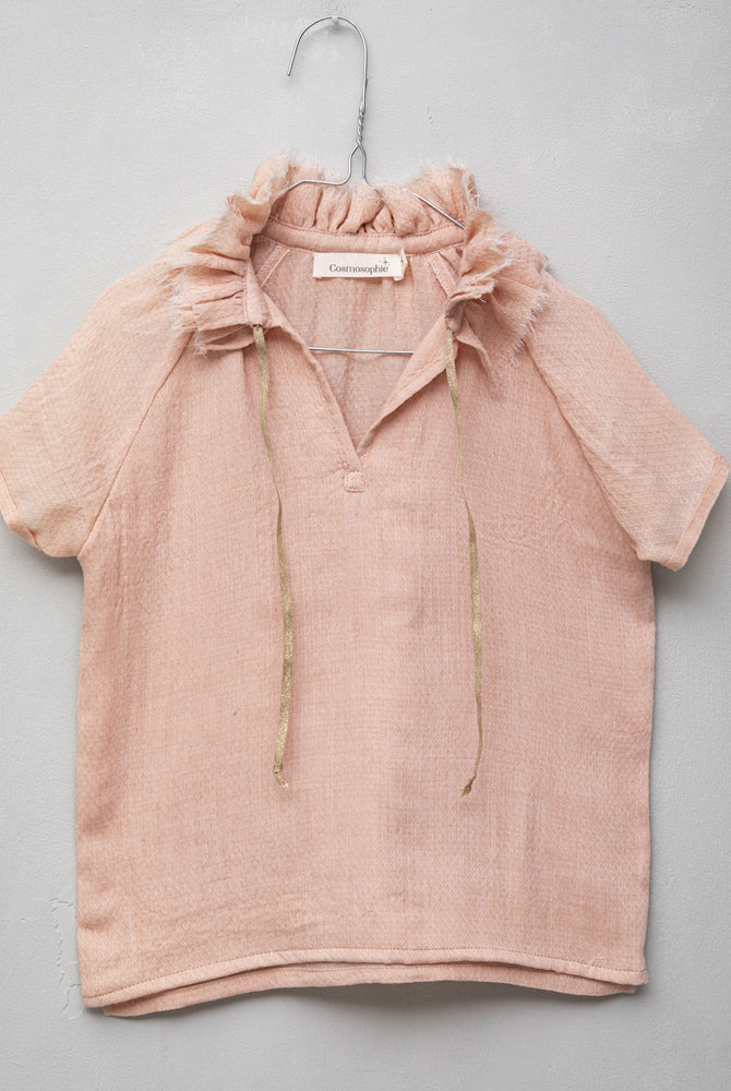 Blusa de mujer rosa con efecto jacquard, cuello de volantes deshilachados y cordones dorados. Diseño femenino y especial.