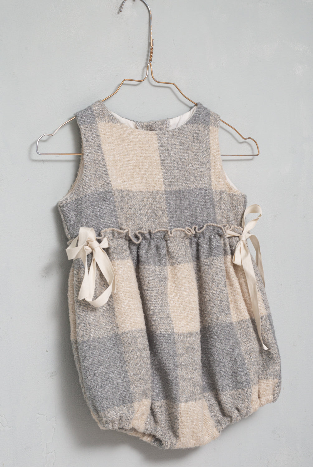 Preciosa ranita pichi en suave tejido de vichy oversize en color crudo y gris azulado. Perfecto para llevar con una de nuestras blusas de cuello de volantes. Te encantarán sus lazadas en los lados.