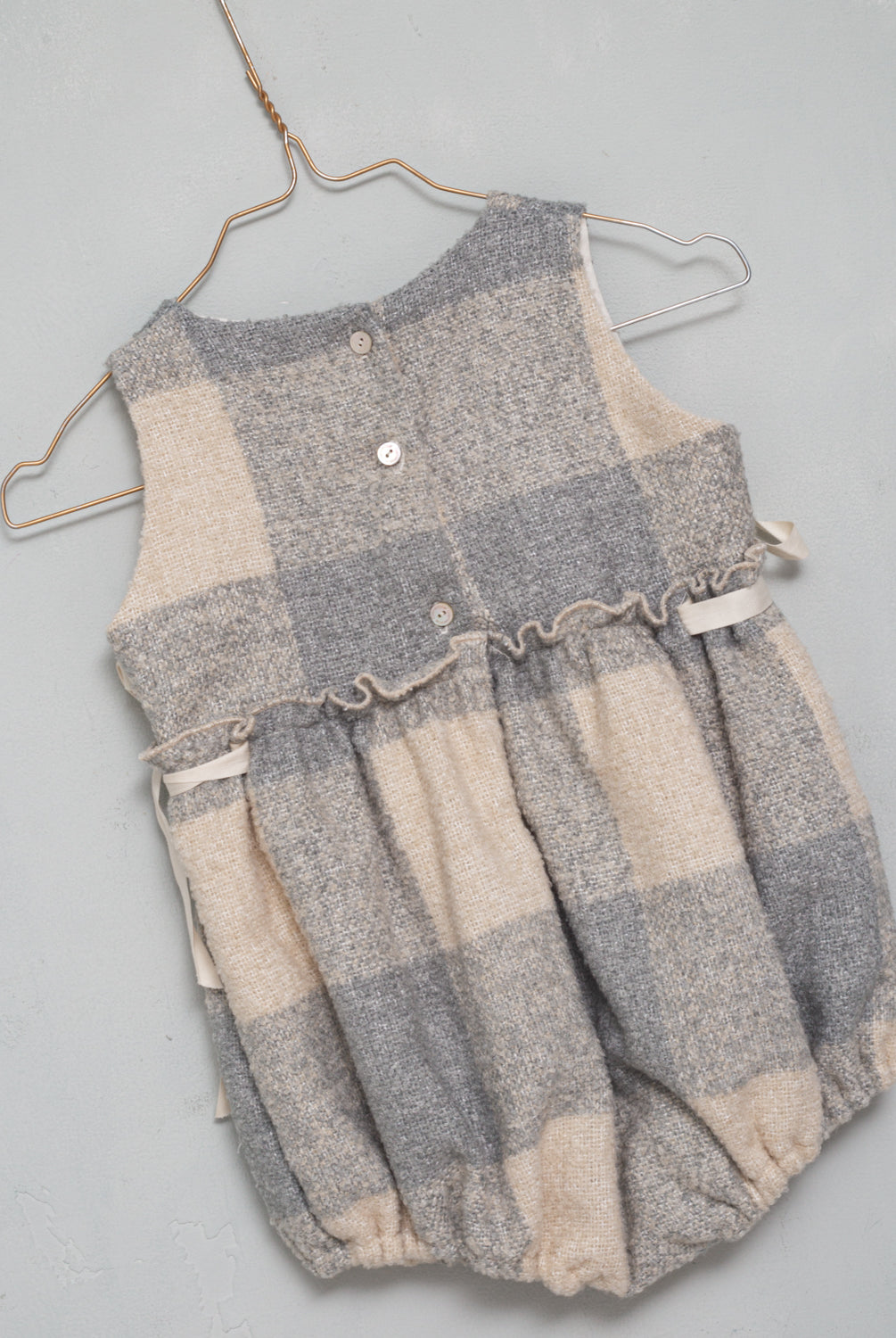 Preciosa ranita pichi en suave tejido de vichy oversize en color crudo y gris azulado. Perfecto para llevar con una de nuestras blusas de cuello de volantes. Te encantarán sus lazadas en los lados.