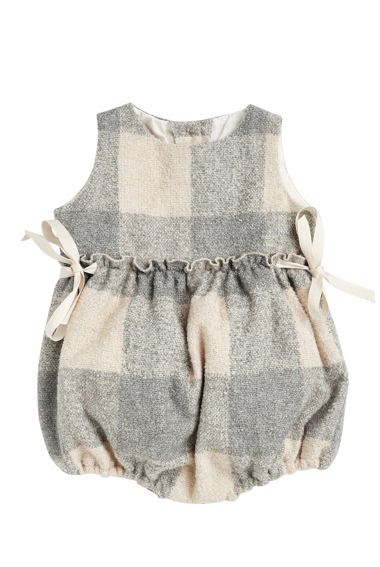 Beautiful pinafore romper in soft oversize gingham fabric in ecru and bluish grey. Perfect to wear with one of our ruffle neck blouses. You will love its bows on the sides.