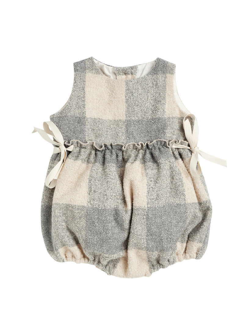 Beautiful pinafore romper in soft oversize gingham fabric in ecru and bluish grey. Perfect to wear with one of our ruffle neck blouses. You will love its bows on the sides.