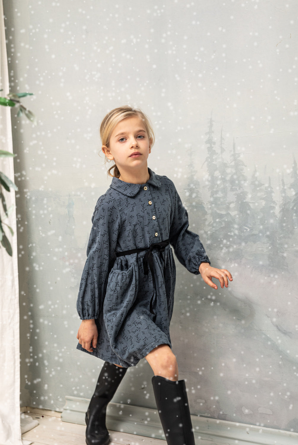 Vestido abierto por delante con botones y cuello bebe. Te encantrá su tejido de doble gasa de color azul con estampado de pequeñas florecitas en negro. Como detalles, lleva una cinta en negro que se anuda en la cintura.