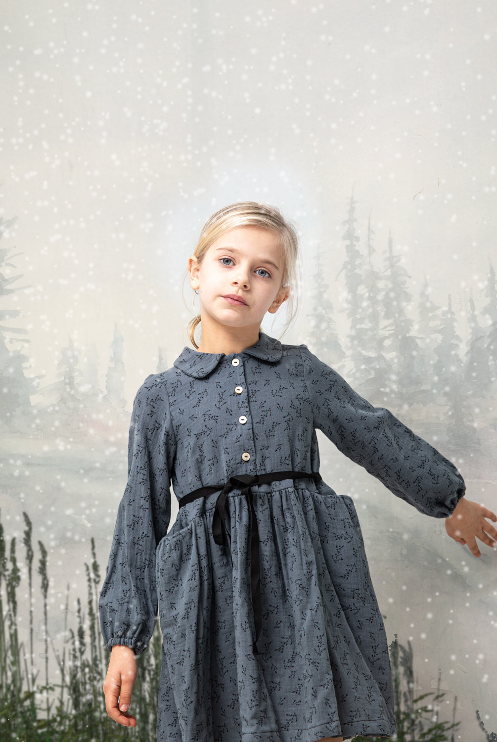 Front button dress with baby collar. You will love its blue double gauze fabric with a print of small black flowers. As details, it has a black ribbon that is tied at the waist.