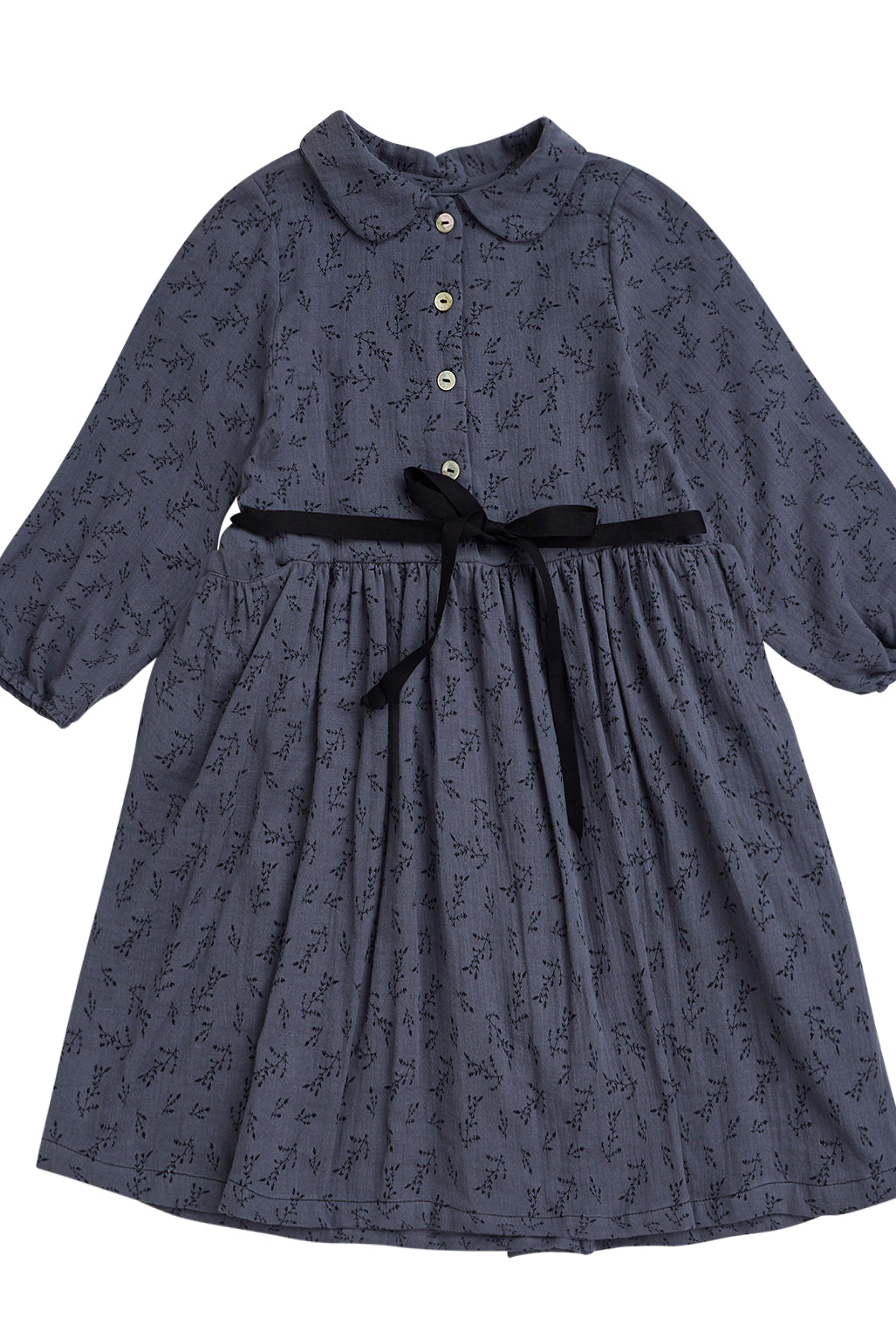 Vestido abierto por delante con botones y cuello bebe. Te encantrá su tejido de doble gasa de color azul con estampado de pequeñas florecitas en negro. Como detalles, lleva una cinta en negro que se anuda en la cintura.
