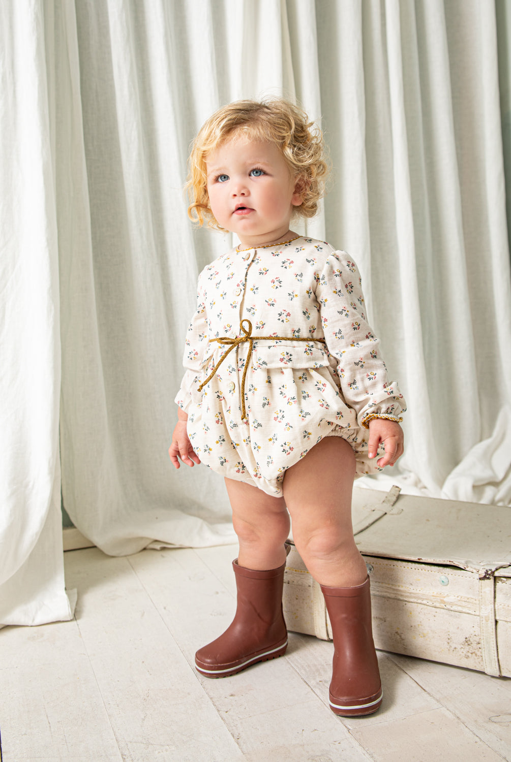 Tu bebe estará preciosa con esta ranita en estampado de flores en color azul, rosa y mostaza sobre fondo crudo. Te encantrá en detalle a contraste en el cuello, sus bolsillos de decoración y su detalle de lazada en la cintura. Se abrocha por delante y entre las piernas para mayor confort.
