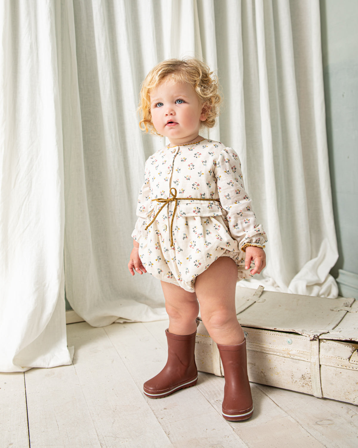 Tu bebe estará preciosa con esta ranita en estampado de flores en color azul, rosa y mostaza sobre fondo crudo. Te encantrá en detalle a contraste en el cuello, sus bolsillos de decoración y su detalle de lazada en la cintura. Se abrocha por delante y entre las piernas para mayor confort.