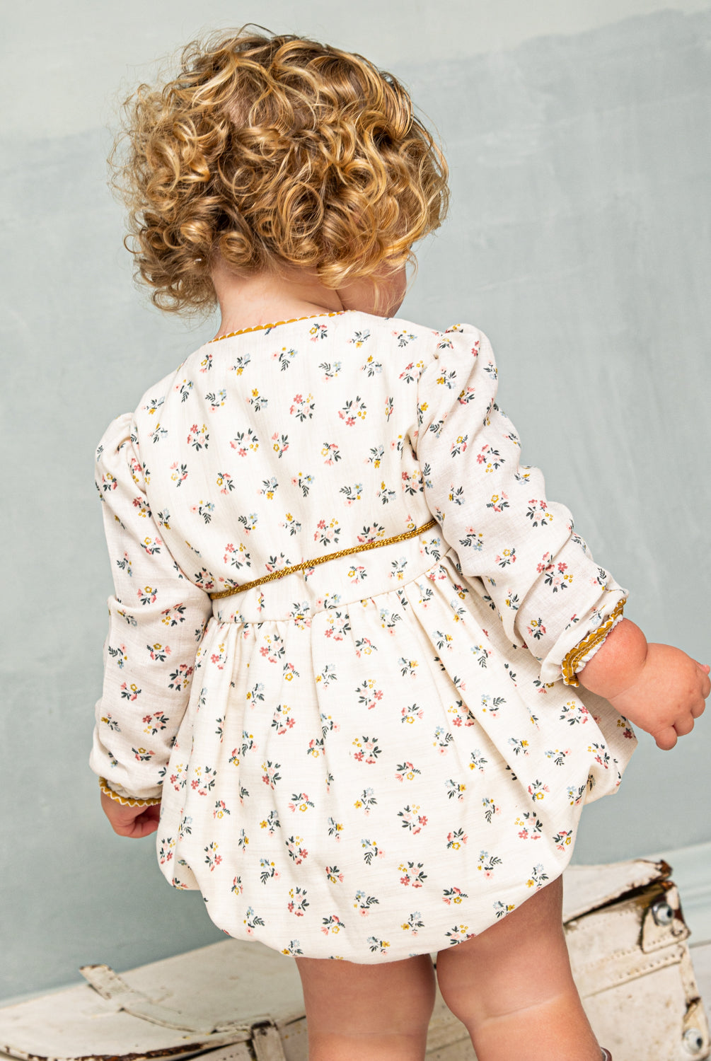 Tu bebe estará preciosa con esta ranita en estampado de flores en color azul, rosa y mostaza sobre fondo crudo. Te encantrá en detalle a contraste en el cuello, sus bolsillos de decoración y su detalle de lazada en la cintura. Se abrocha por delante y entre las piernas para mayor confort.