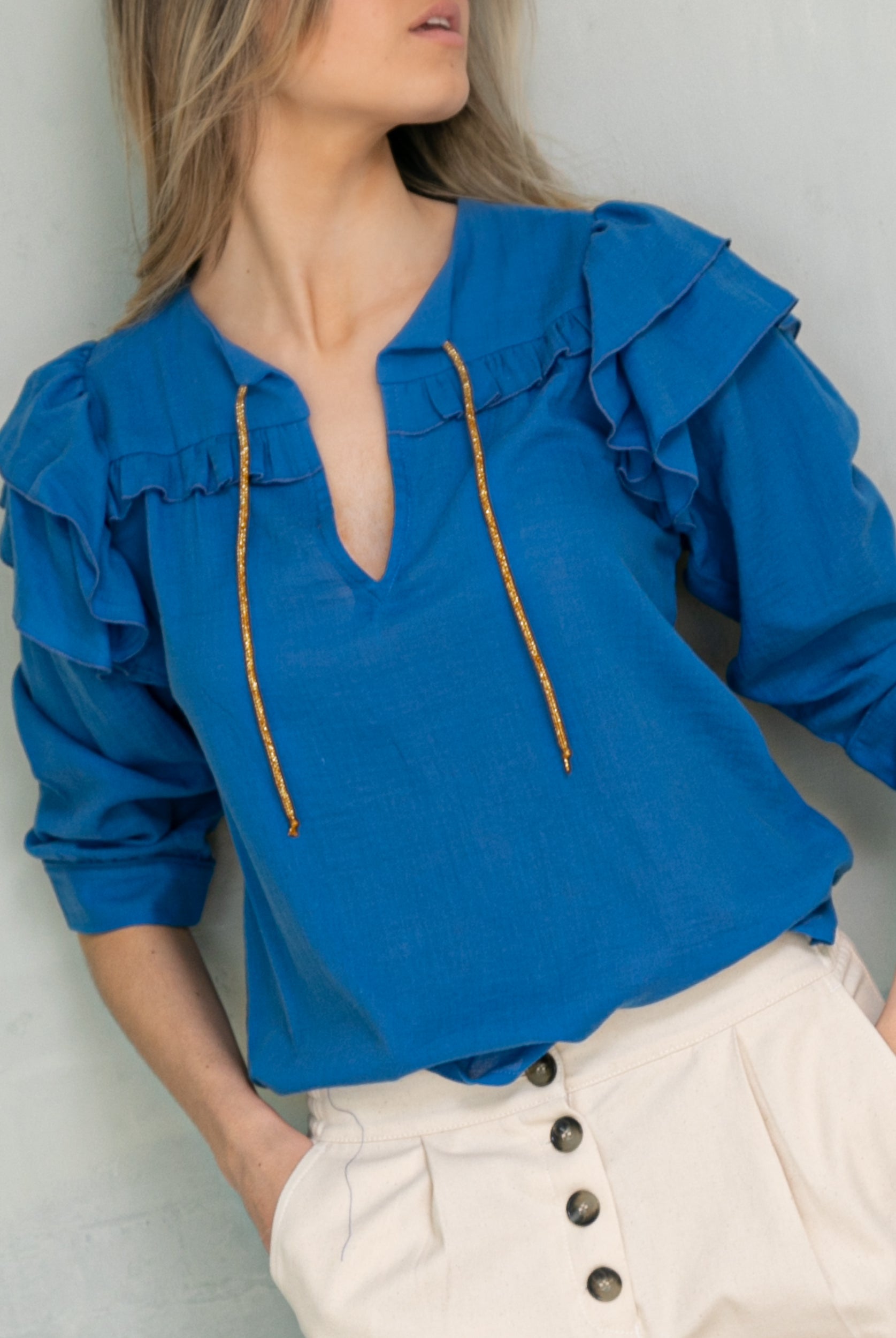 Blusa en algodon vaporoso azul cian con doble volante en el hombro y lazada en oro