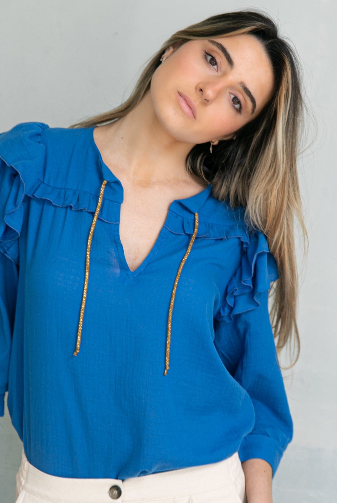 Blusa en algodon vaporoso azul cian con doble volante en el hombro y lazada en oro