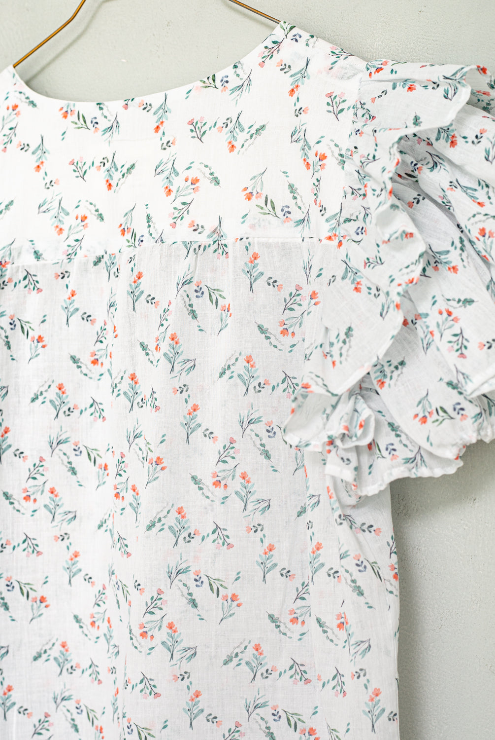Detalle de blusa de flores romantica tendencia de volantes para una cena. Cosmosophie. Modelo Wolf