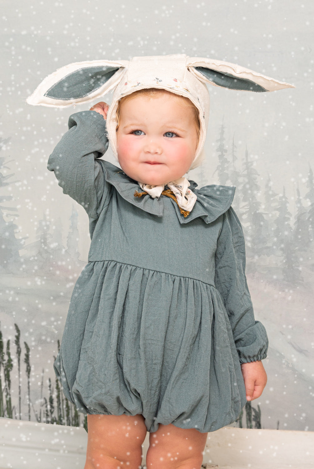 Ranita azul con cuello de volante y lazada en oro para bebe.