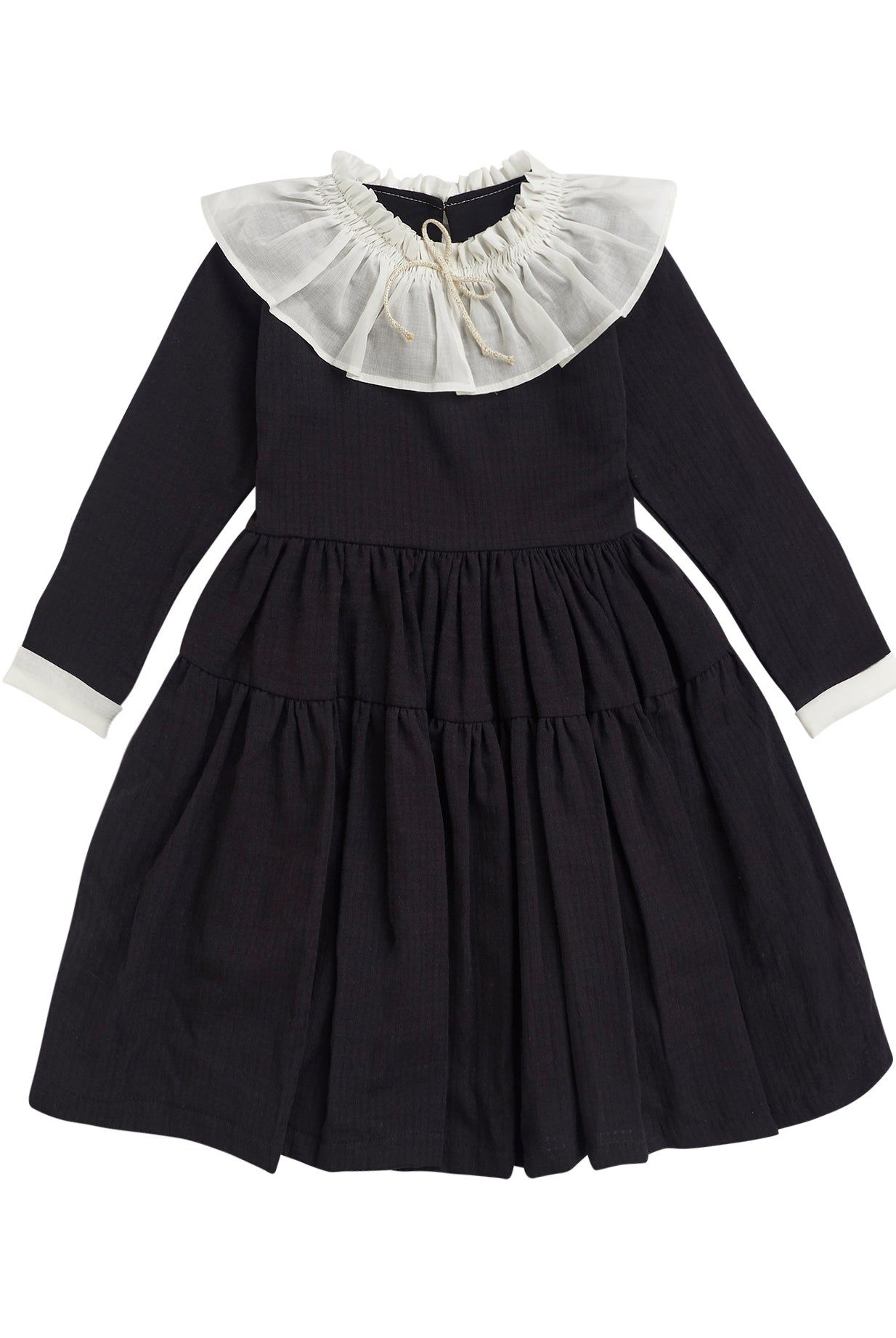 One of the most romantic dresses in the collection. Made of black cotton with gingham jacquard. You'll love its huge, gathered collar in off-white muslin. Small bow detail on the neck in an ecru and gold tone. The sleeve has a contrasting off-white muslin detail. Double flounce skirt. It buttons in the back.