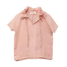 Blusa de mujer rosa con efecto jacquard, cuello de volantes deshilachados y cordones dorados. Diseño femenino y especial.