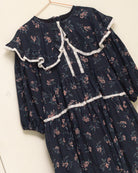 Vestido infantil romántico de voile de algodón azul noche con estampado floral y detalles de encaje Valencienne. Un diseño especial y atemporal.