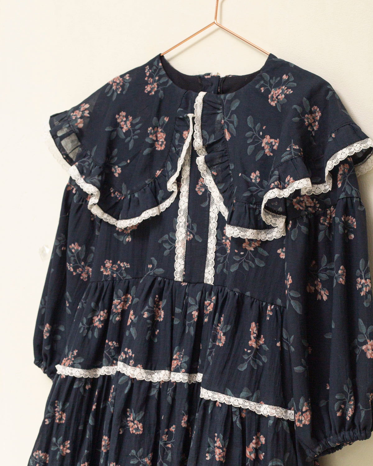 Vestido infantil romántico de voile de algodón azul noche con estampado floral y detalles de encaje Valencienne. Un diseño especial y atemporal.
