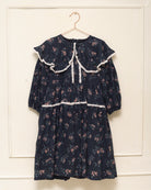 Vestido infantil romántico de voile de algodón azul noche con estampado floral y detalles de encaje Valencienne. Un diseño especial y atemporal.