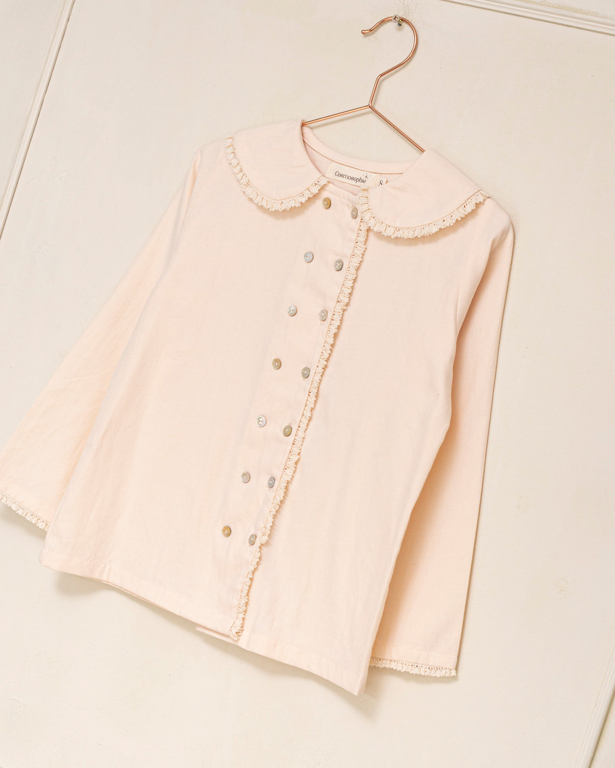 Blusa elegante para niña de algodón con cuello Peter Pan, doble botonadura y delicados detalles de encaje. Diseño atemporal de Cosmosophie para looks especiales…