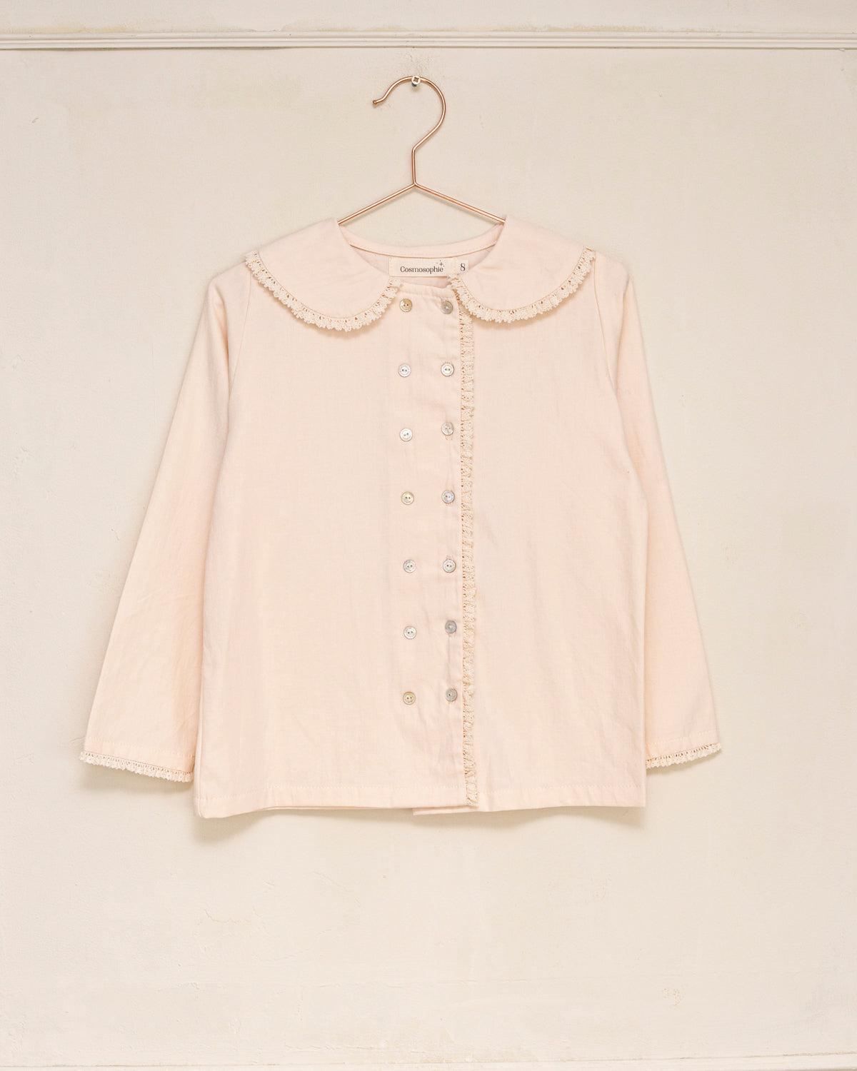 Blusa elegante para niña de algodón con cuello Peter Pan, doble botonadura y delicados detalles de encaje. Diseño atemporal de Cosmosophie para looks especiales…