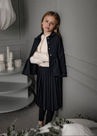 Falda Bert Glow plisada para niña, confeccionada en 100% poliéster con un sutil brillo. Diseño elegante y versátil, confeccionado en España.