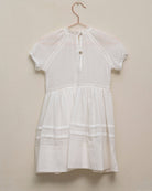 Vestido en blanco roto con lazitos en el pecho y encajes, falda con lorzas y pololos a juego Cosmosophie