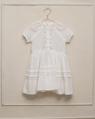 Vestido en blanco roto con lazitos en el pecho y encajes, falda con lorzas y pololos a juego Cosmosophie