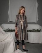 Vestido-abrigo Seven para niña en lana fría de poliéster con cuadros plaid Roble, botones ocultos y cinturón dorado. Elegante y versátil.