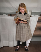 Vestido Tola de niña en cuadro de Gales con lentejuelas, cuello de terciopelo y mangas abullonadas. Diseño romántico y sofisticado.