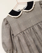 Vestido Tola de niña en cuadro de Gales con lentejuelas, cuello de terciopelo y mangas abullonadas. Diseño romántico y sofisticado.