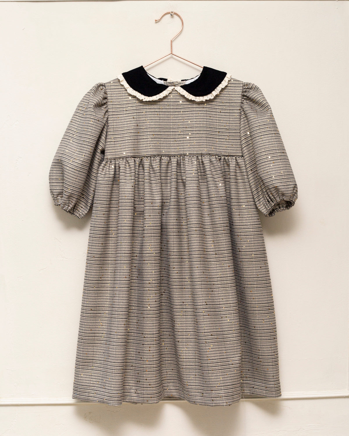 Vestido Tola de niña en cuadro de Gales con lentejuelas, cuello de terciopelo y mangas abullonadas. Diseño romántico y sofisticado.