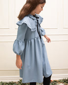 Vestido azul celeste con capita con volantes y lazo negro. cosmosophie