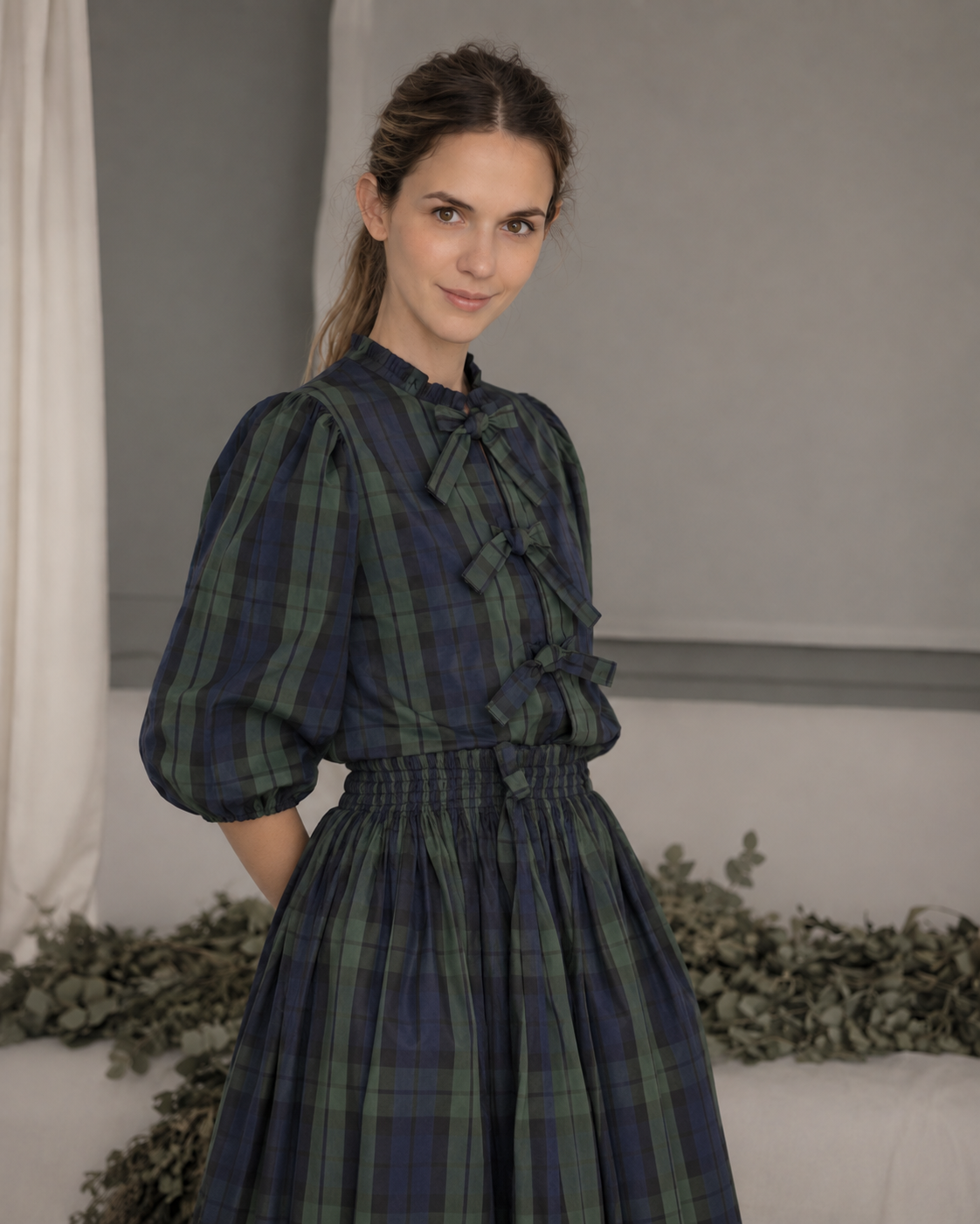 Blusa de tafetán de cuadros en verde y azul marino, con manga al codo y cierre delantero con lazos. Diseño elegante confeccionado en Madrid.